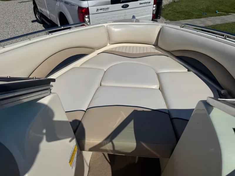 Slide: The Image of 1999 Caravelle 209 Bow Rider boat interior with beige seating and spacious layout. - 13