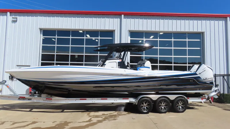 The Image of 2023 Sunsation 32 CCX boat on trailer, parked outside a garage. - 0