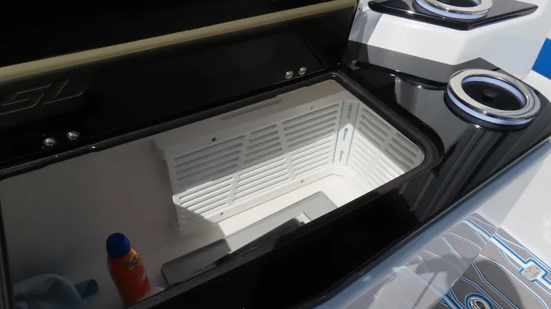 Slide: The Image of 2023 Sunsation 32 CCX boat storage compartment with cup holders and sunscreen bottle. - 10
