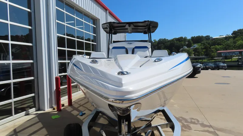 Slide: The Image of 2023 Sunsation 32 CCX boat on trailer, parked outside a building under clear blue sky. - 4