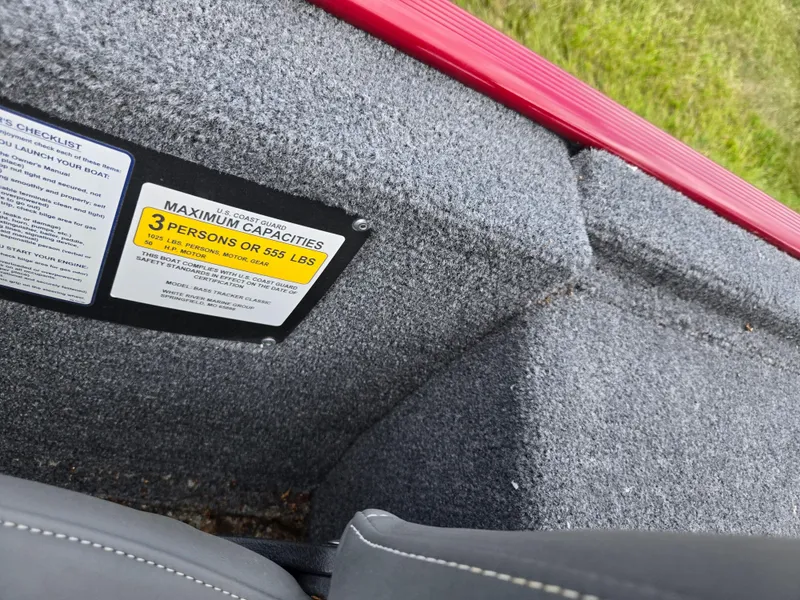 Slide: The Image of 2024 Tracker Bass Tracker Classic XL boat capacity label, gray interior, red trim. - 12