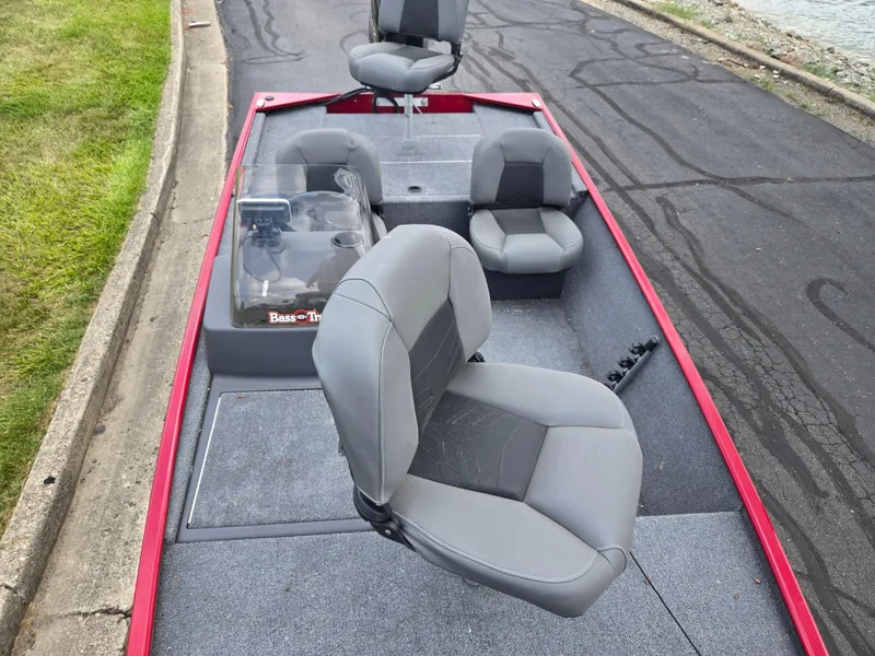Slide: The Image of 2024 Tracker Bass Tracker Classic XL boat with gray seating and red trim on a paved surface. - 17