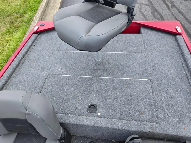 Slide: The Image of 2024 Tracker Bass Tracker Classic XL boat deck with gray seating and red accents. - 19