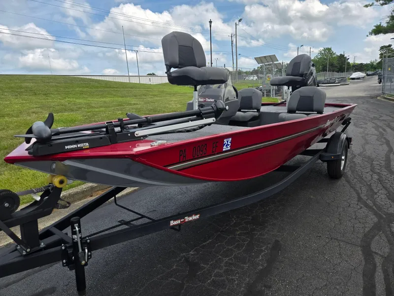 Slide: The Image of 2024 Tracker Bass Tracker Classic XL boat on trailer, red and gray, parked outdoors. - 6