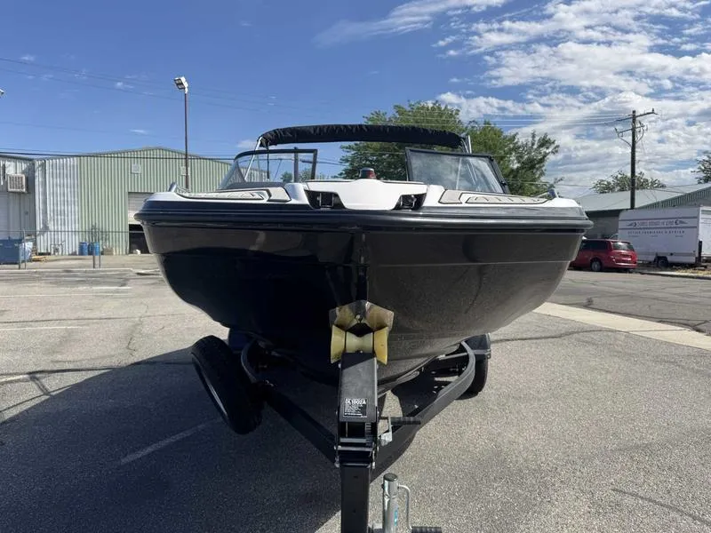 Slide: The Image of 2022 Yamaha Boats SX210 on trailer, parked outdoors under a partly cloudy sky. - 3