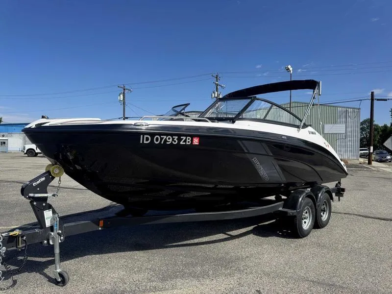 Slide: The Image of 2022 Yamaha Boats SX210 on trailer, parked outdoors under clear blue sky. - 4
