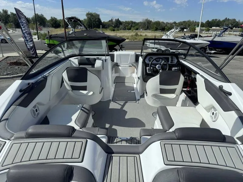 Slide: The Image of 2022 Yamaha Boats SX210 interior with seating and steering wheel, displayed outdoors. - 6