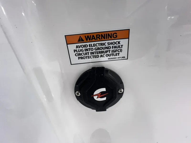 Slide: The Image of Warning label and outlet on 2026 Blackfin 242 HB boat, cautioning against electric shock. - 10