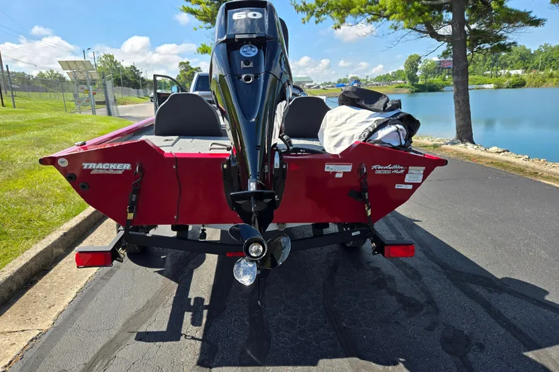 Slide: The Image of 2024 Tracker Pro Team 175 TXW boat on trailer by a lake. - 2