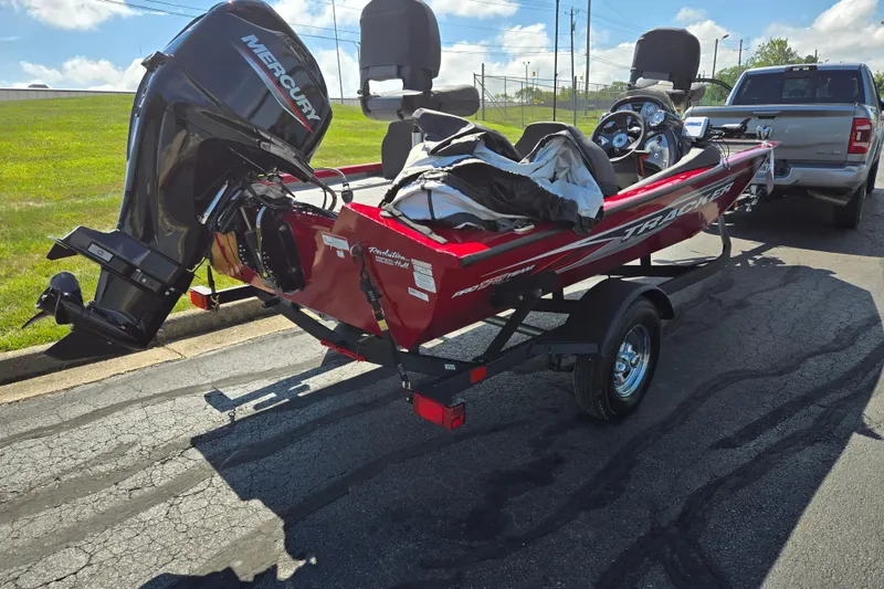 Slide: The Image of 2024 Tracker Pro Team 175 TXW boat on trailer, parked near a pickup truck. - 3