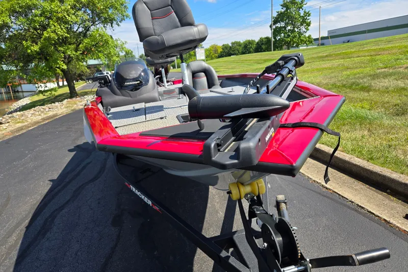 Slide: The Image of 2024 Tracker Pro Team 175 TXW boat with red detailing, parked on pavement. - 6