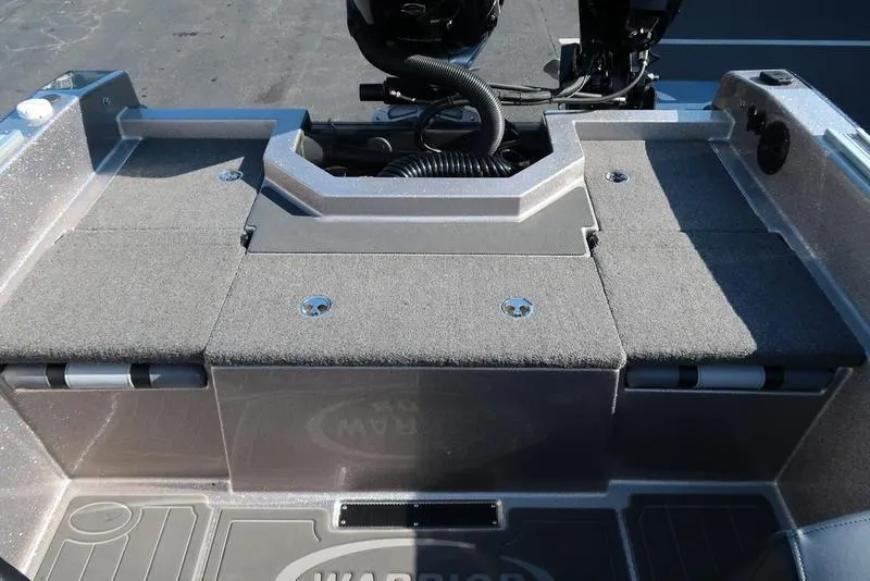 Slide: The Image of 2024 Warrior 238 DC boat interior with carpeted deck and motor area. - 12