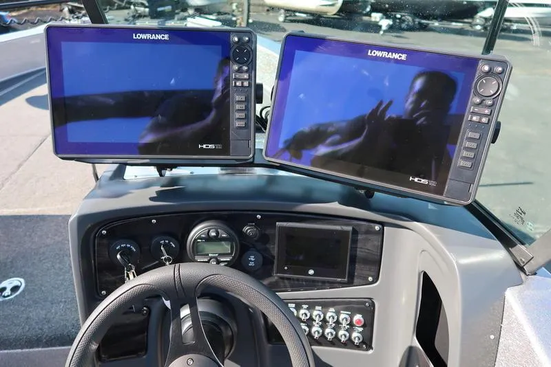 Slide: The Image of 2024 Warrior 238 DC boat dashboard with dual Lowrance HDS displays and steering wheel. - 14