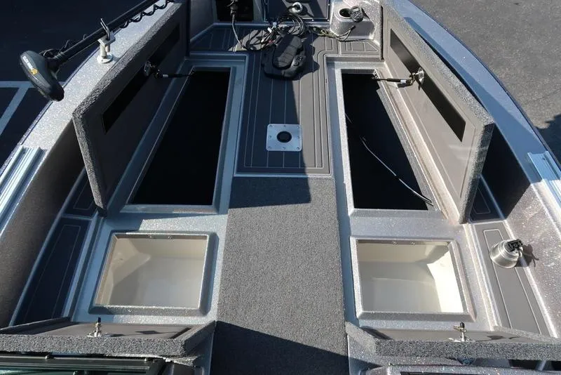 Slide: The Image of 2024 Warrior 238 DC boat interior with open storage compartments and fishing equipment. - 2