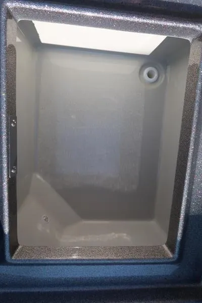 Slide: The Image of 2024 Warrior 238 DC boat compartment, empty storage space with drain hole. - 25