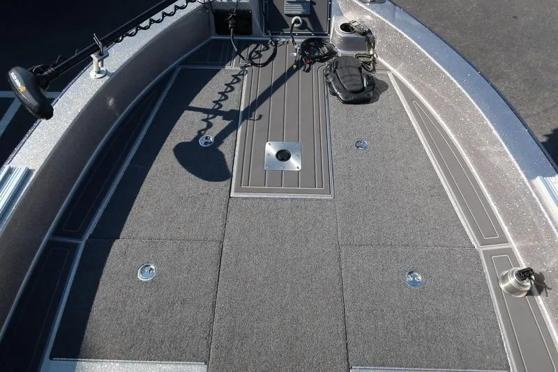 Slide: The Image of 2024 Warrior 238 DC boat deck with carpeted flooring and fishing equipment. - 26