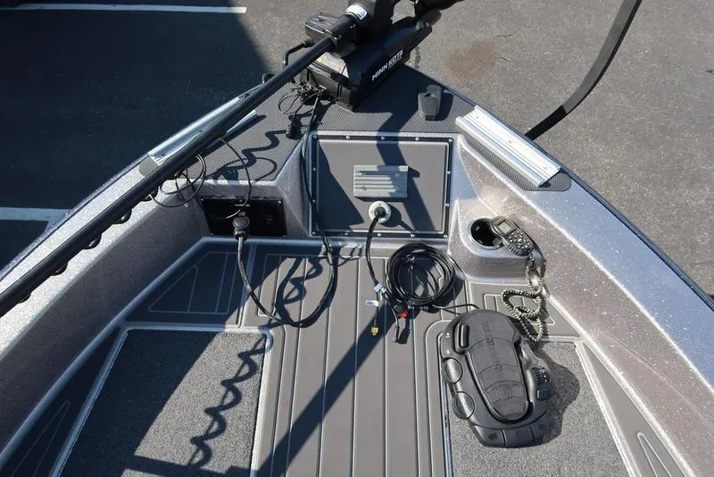 Slide: The Image of 2024 Warrior 238 DC boat deck with fishing equipment and control panel. - 29