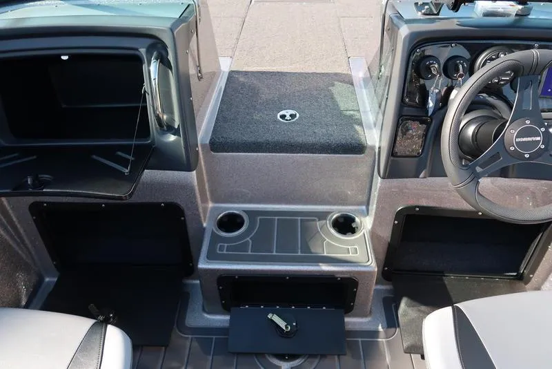 Slide: The Image of 2024 Warrior 238 DC boat interior with steering wheel, dashboard, and storage compartments. - 31