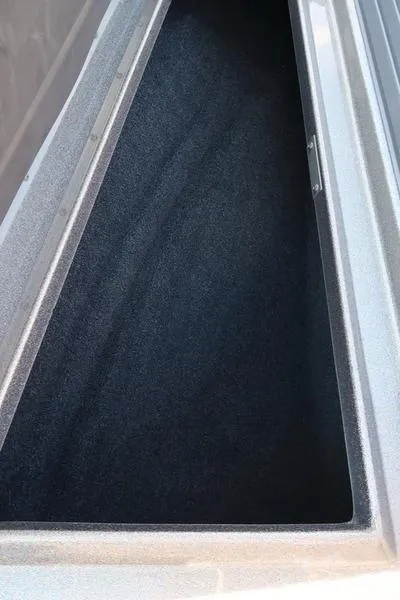 Slide: The Image of 2024 Warrior 238 DC boat storage compartment, featuring a sleek, carpeted interior. - 32