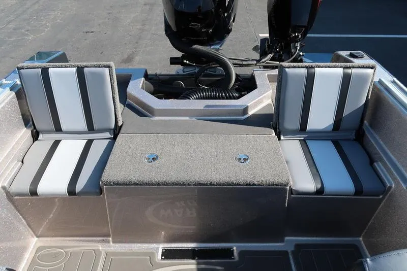 Slide: The Image of 2024 Warrior 238 DC boat interior with dual seating and motor view. - 7