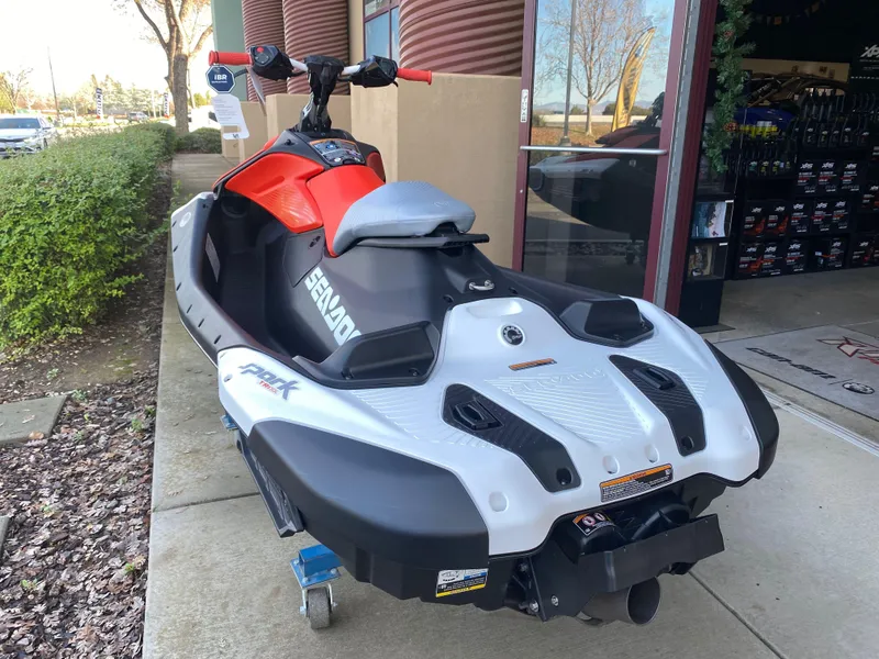 Slide: The Image of 2024 Sea-Doo Spark Trixx for 1, parked outside a showroom, showcasing sleek design. - 6
