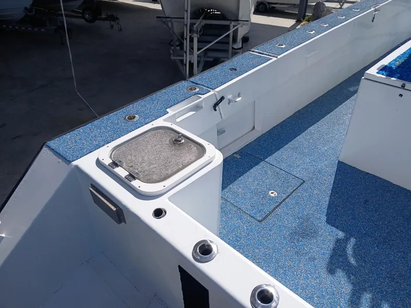 Slide: The Image of 2023 Razor Cat 37 Cat boat deck with blue flooring and storage compartments. - 11