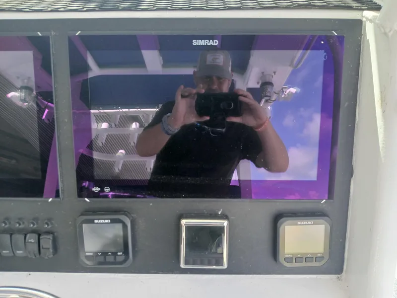 Slide: The Image of Control panel of a 2023 Razor Cat 37 Cat boat with digital displays and reflection. - 14