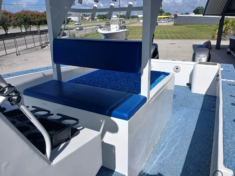 Slide: The Image of 2023 Razor Cat 37 Cat boat interior with blue seating and deck, parked outdoors. - 22