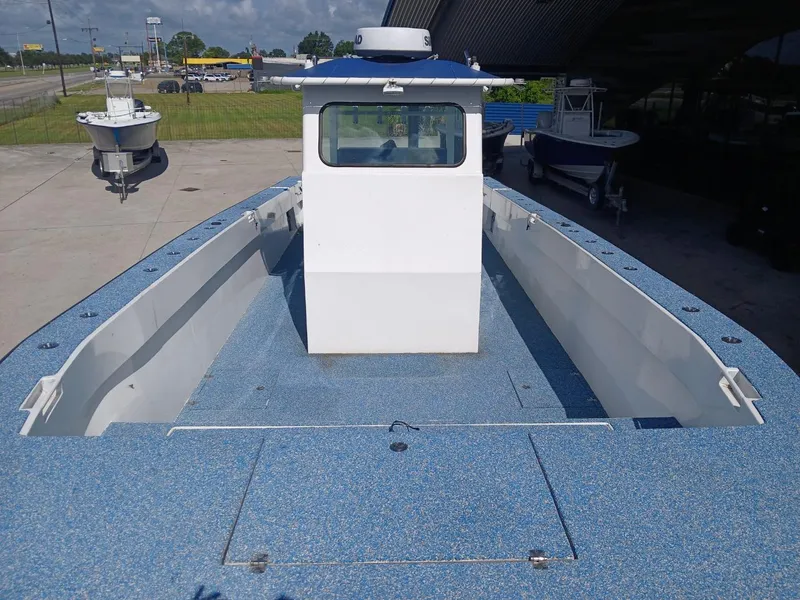 Slide: The Image of 2023 Razor Cat 37 Cat boat with blue deck, docked outdoors. - 23