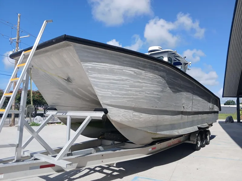 Slide: The Image of 2023 Razor Cat 37 Cat boat on trailer under clear blue sky. - 25