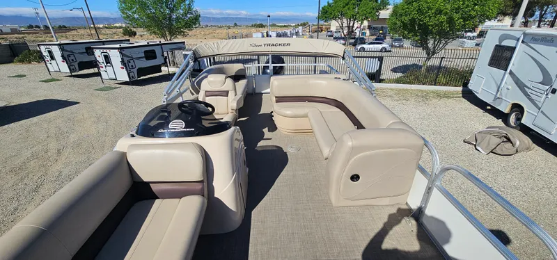 Slide: The Image of 2017 Sun Tracker Party Barge 240 pontoon boat with spacious seating and helm, parked outdoors. - 10