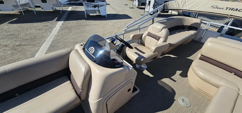 Slide: The Image of 2017 Sun Tracker Party Barge 240 interior with beige seating and steering console. - 11