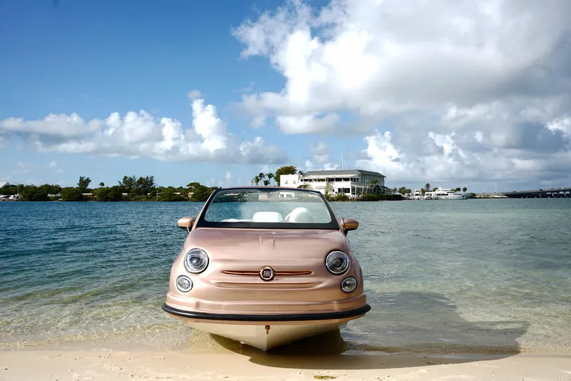 Slide: The Image of Rose Gold Fiat 500 floating on water, 2026 model, with scenic coastal backdrop. - 27