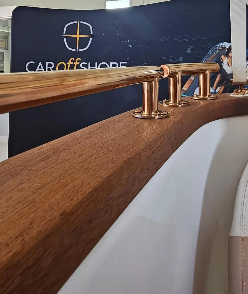 Slide: The Image of Wooden and copper railing detail with Car Off-shore branding in the background. - 9