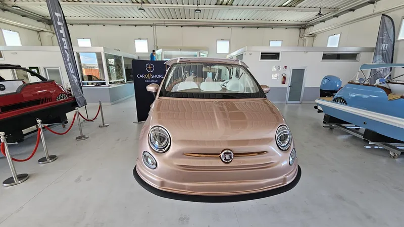 Slide: The Image of 2026 Fiat 500 Rose Gold car and boat hybrid at a dockside crane. - 2