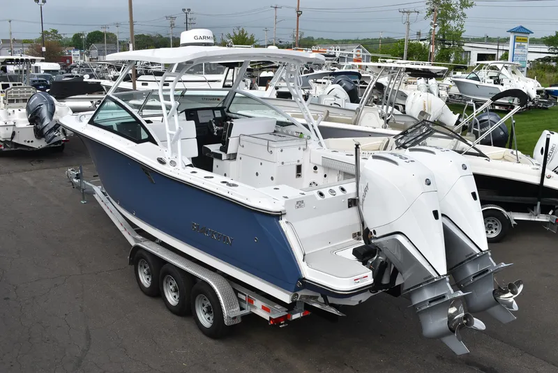 Slide: The Image of 2025 Blackfin 272 DC boat with dual engines on a trailer in a marina. - 4