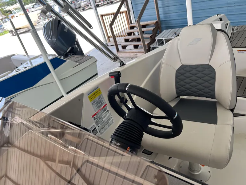 Slide: The Image of 2026 Starcraft SVX 231 OB boat interior with steering wheel and captain's chair. - 14