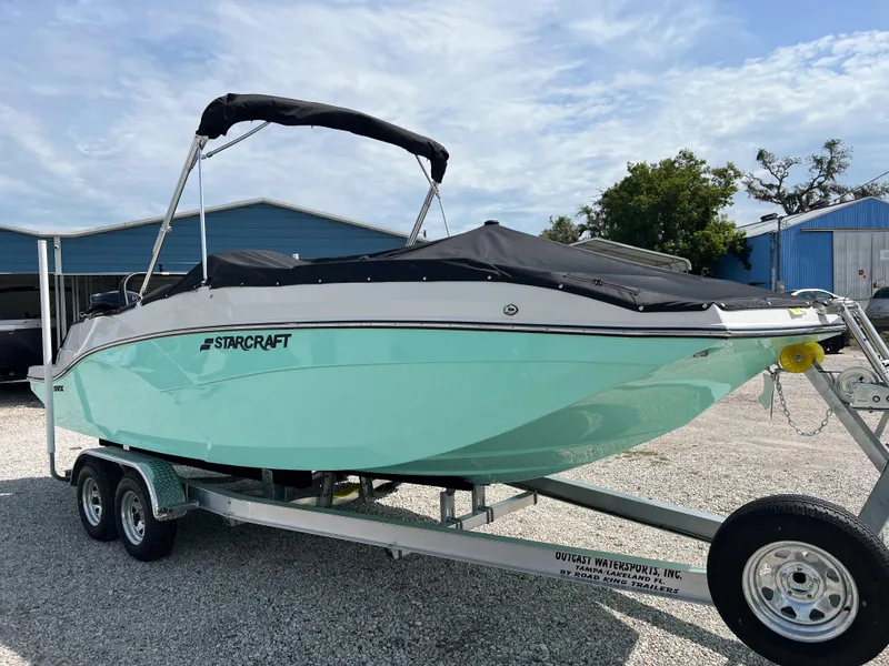Slide: The Image of 2026 Starcraft SVX 231 OB boat on trailer, parked outdoors under a cloudy sky. - 5