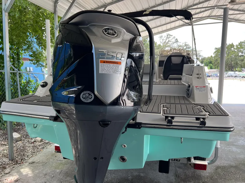 Slide: The Image of 2026 Starcraft SVX 231 OB boat with powerful outboard motor, docked under a canopy. - 6