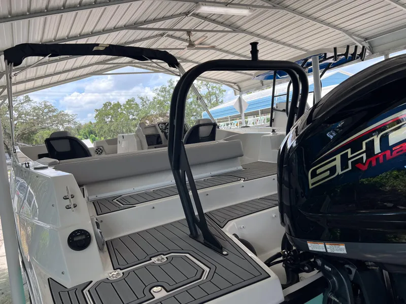 Slide: The Image of 2026 Starcraft SVX 231 OB boat under a canopy, featuring sleek interior and powerful engine. - 8