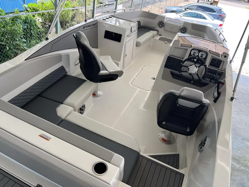 Slide: The Image of 2026 Starcraft SVX 231 OB boat interior with modern seating and steering console. - 9