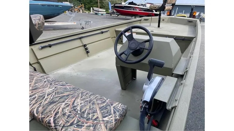 Slide: The Image of 2025 Lowe Roughneck RX1860 SC boat interior with steering wheel and camo seating. - 6