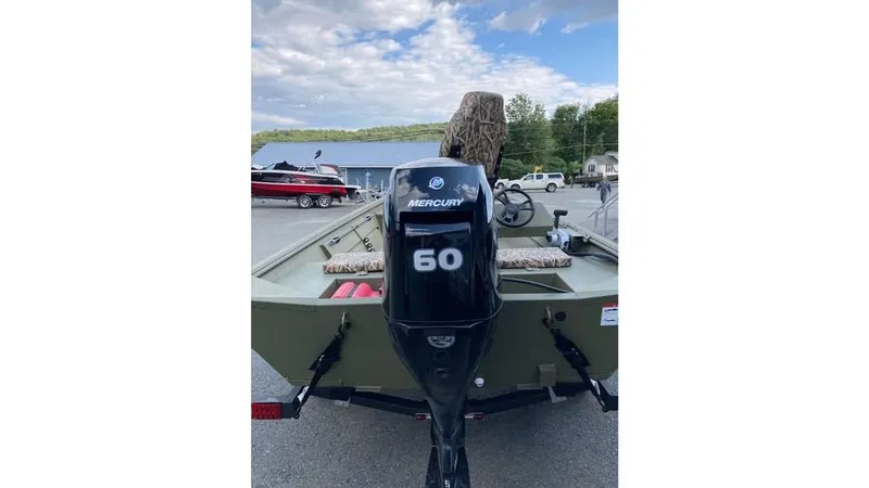 Slide: The Image of 2025 Lowe Roughneck RX1860 SC boat with Mercury 60 outboard motor, parked outdoors. - 7