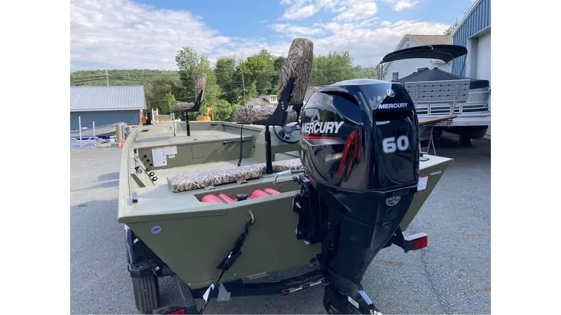Slide: The Image of 2025 Lowe Roughneck RX1860 SC boat with Mercury 60 outboard motor, parked outdoors. - 8