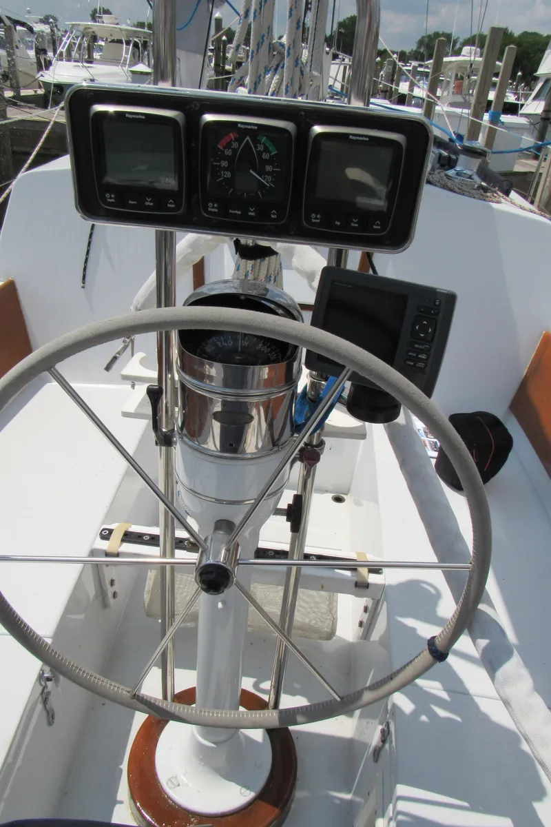 Slide: The Image of Steering wheel and instruments on a 1968 CAL 34 sailboat, docked at a marina. - 12