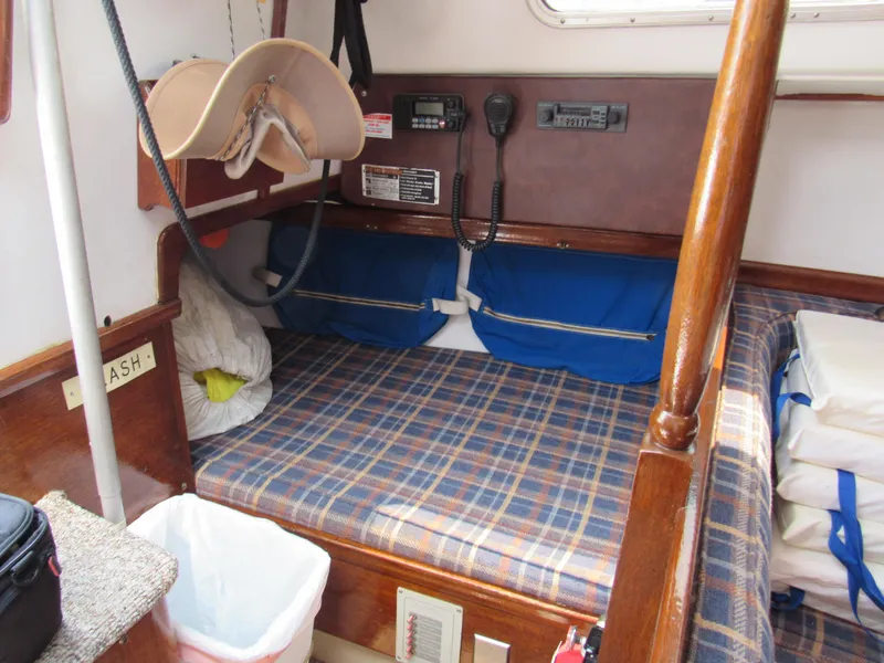 Slide: The Image of Interior of a 1968 CAL 34 sailboat with plaid bedding and nautical equipment. - 4