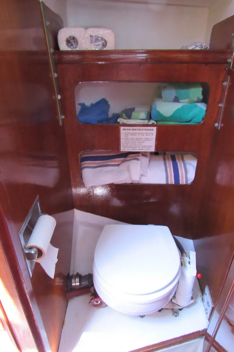 Slide: The Image of 1968 CAL 34 yacht bathroom with wooden cabinetry, toilet, and storage shelves. - 8
