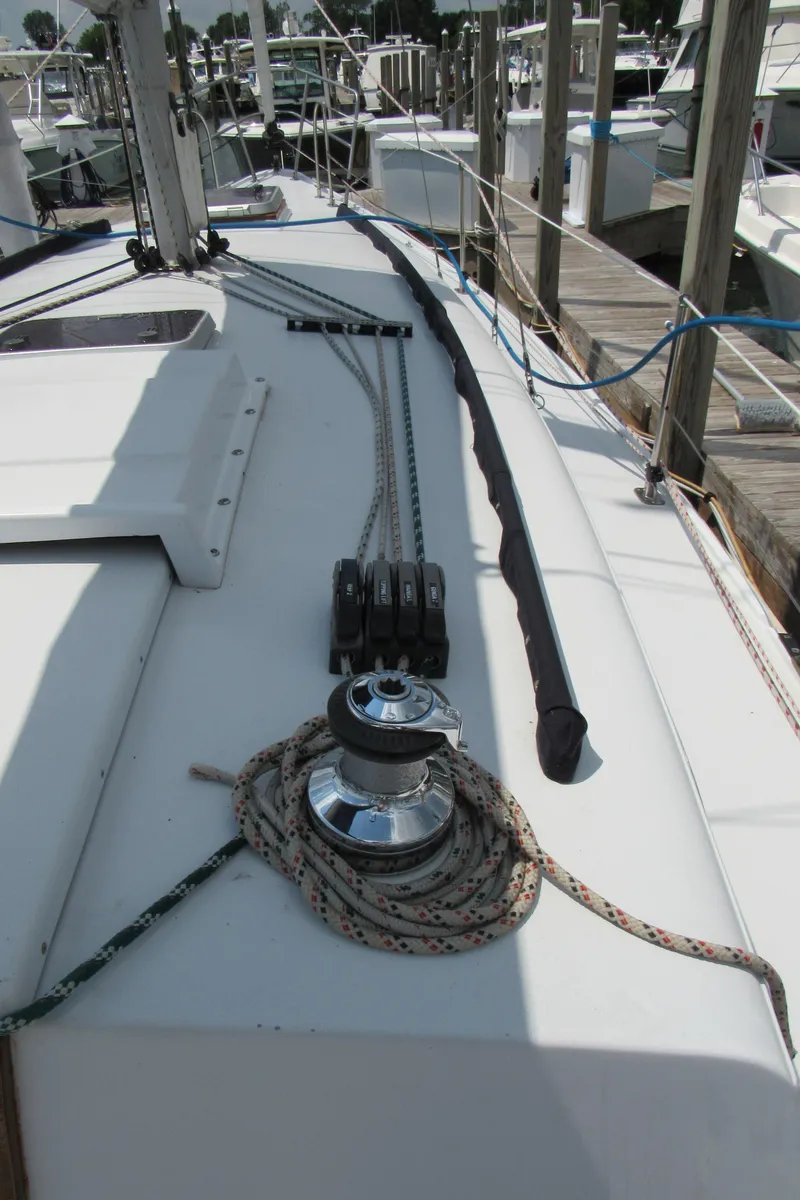 Slide: The Image of 1968 CAL 34 sailboat deck with winch and ropes at marina. - 9
