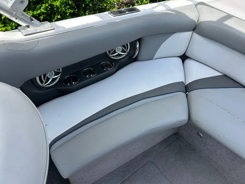 Slide: The Image of 2010 Supra Launch 21 V boat interior with gray and white seating, cup holders, and speakers. - 12