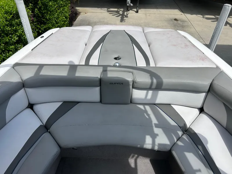 Slide: The Image of 2010 Supra Launch 21 V boat interior with gray and white seating. - 13